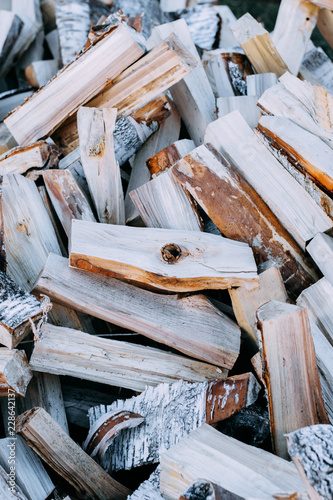 Firewood background - chopped firewood on a stack. Dry chopped firewood logs in a pile.