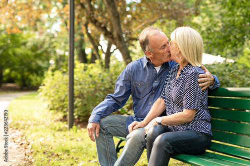 A Senior couple sitting on a park bench shallow depth of field © Louis-Photo