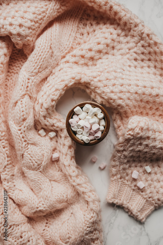 Vertical shot of pink sweater with marshmallows. Cosy concept.