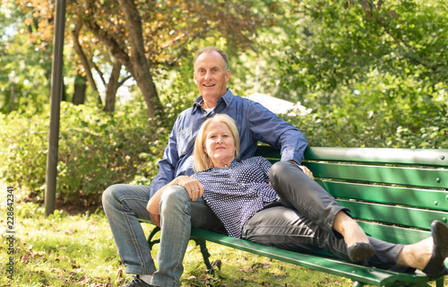 A Senior couple sitting on a park bench shallow depth of field