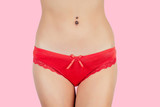 Close-up of sexy red panties on a woman on a pink background in the studio.The concept of depilation, epilation and removal unwanted hair in the bikini zone