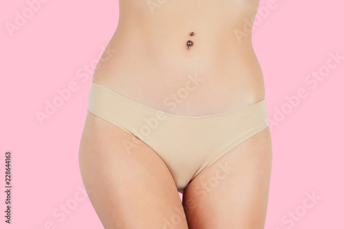 Anti-cellulite massage.Woman in beige panties massaging thigh massage receiving a professional anti cellulite cans (jars, banks) ventuza vacuum leg hips and butt ass on a pink background in the studio