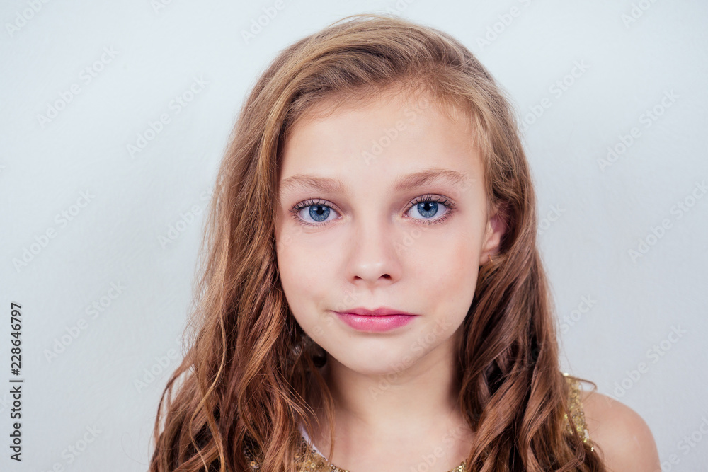 Naklejka premium Portrait of a lovely little teenager schoolgirl girl curly blonde hairstyle