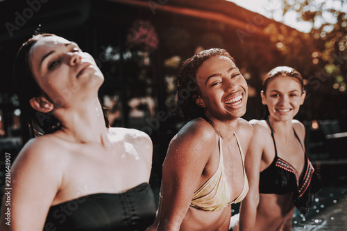 Group of Young Smiling Women Sitting at Poolside © VadimGuzhva