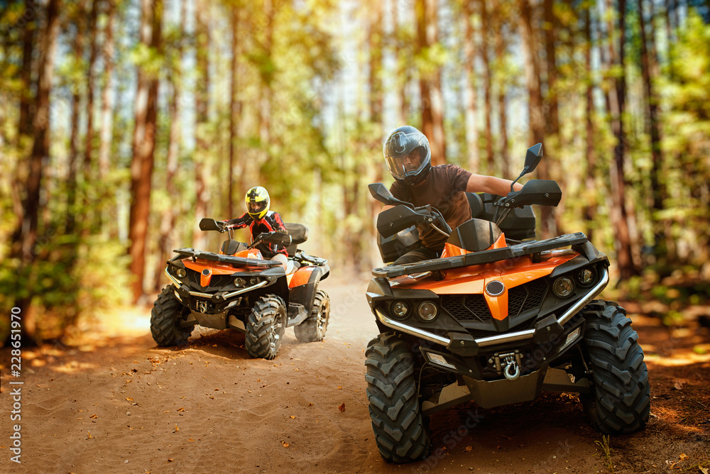 Two atv riders, speed race in forest, front view - obrazy, fototapety, plakaty 