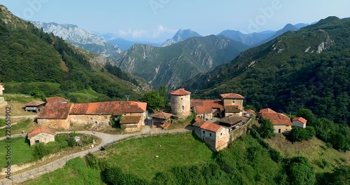 Fly moving away on the top of the mountains with old buildings in front photo