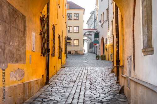 Narrow cobblestone street leading upwards flanked by historical buildings in the old town of Olomouc, Czech Republic
