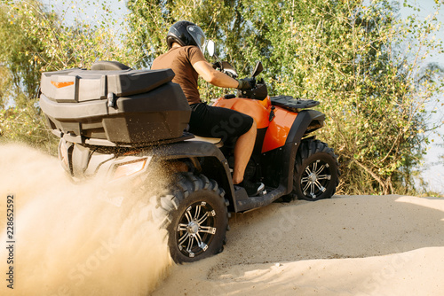 Atv riding in action, sand quarry on background