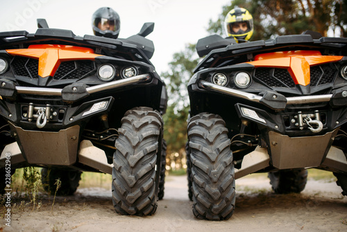 Two riders on quad bikes, front view, closeup