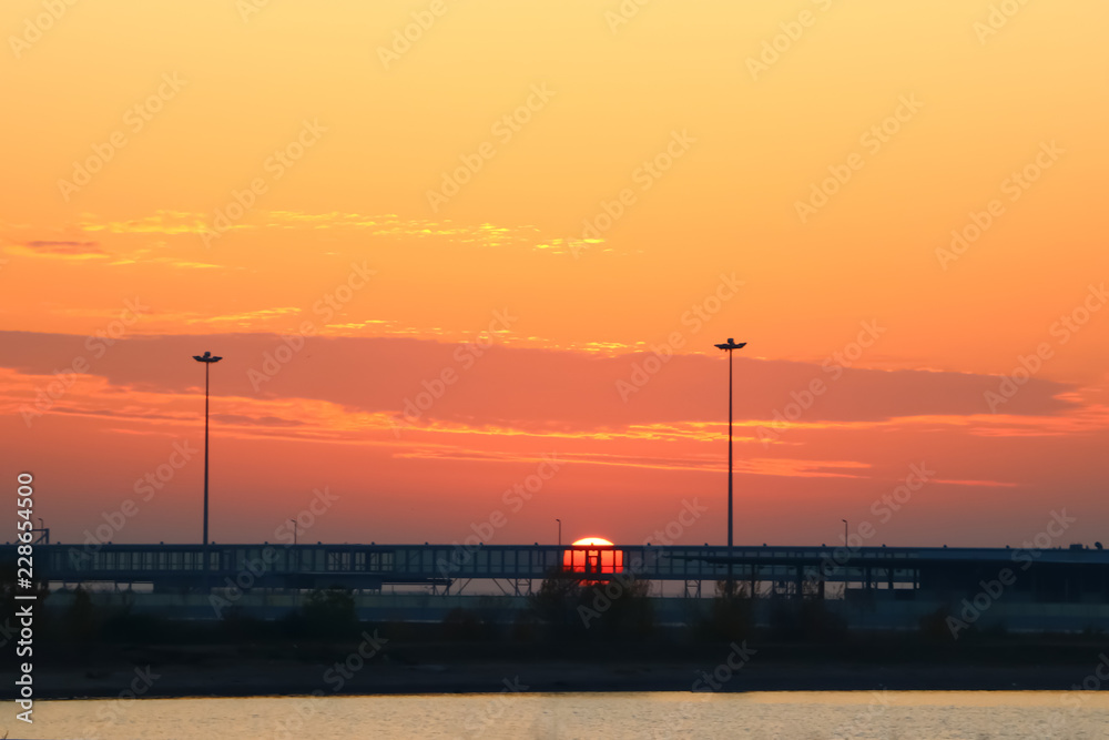 bright sunset with red sun on the background of the port