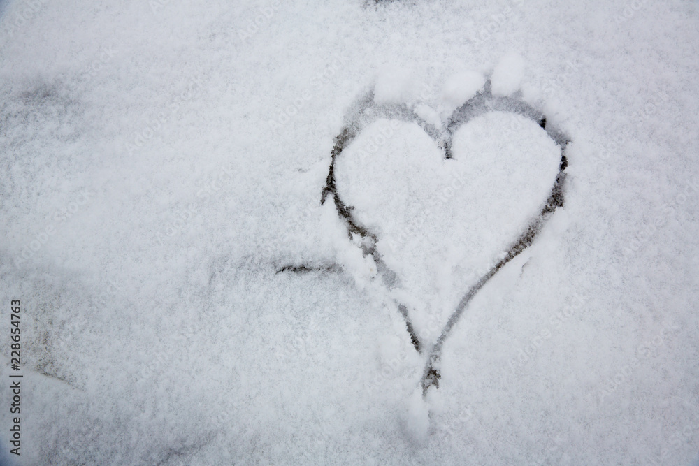 The symbol of the heart, painted on the fresh white snow.drawn heart in the snow.Image of the heart in the snow.