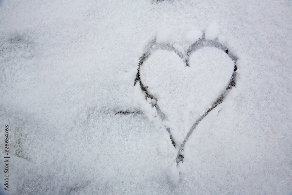 The symbol of the heart, painted on the fresh white snow.drawn heart in the snow.Image of the heart in the snow. The symbol of the heart, painted on the fresh white snow.drawn heart in the snow.Image of the heart in the snow.
