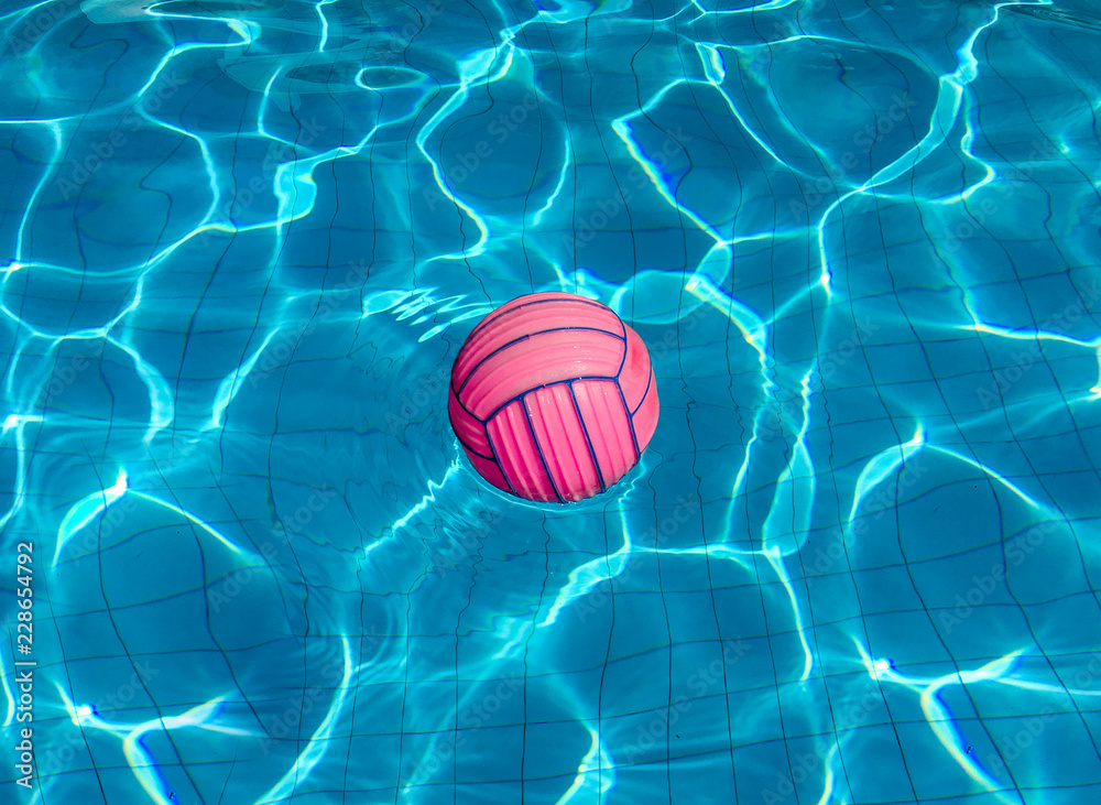 pink basketball, ball in blue turquoise water in the pool