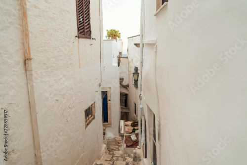 Little alley in the medieval white village of Ostuni at sunset