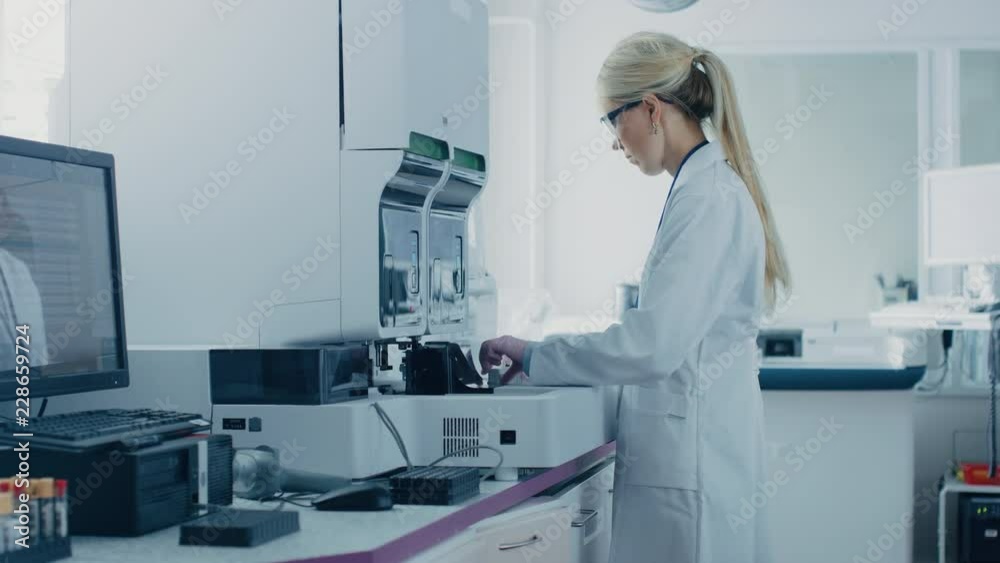 In Bio Technological Laboatory Female Research Scientist Analyzes Test Tube in Medical Machine, Works with Blood, Genetic Material Samples. In Bio Technological Laboatory Female Research Scientist Analyzes Test Tube in Medical Machine, Works with Blood, Genetic Material Samples.