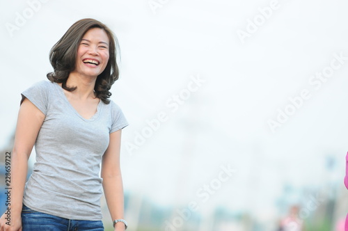 Asian girl smiling and feeling happy in the park in a sunny summer day, Have a beautiful day and happy concept.