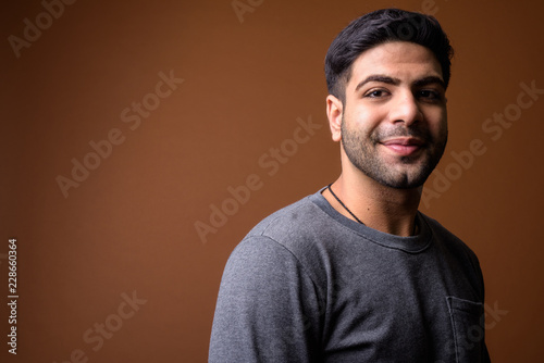 Quadro su tela Young handsome Indian man against brown background