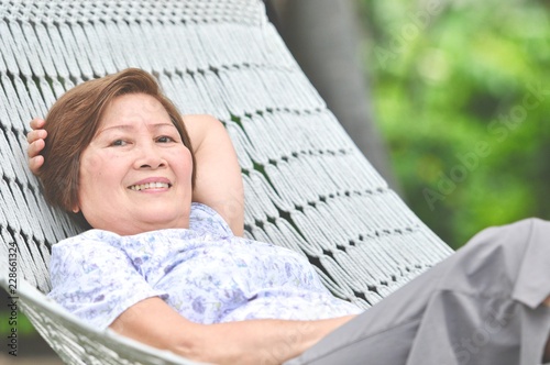 woman relaxing and smiling on hammock, Summer garden with hanging hammock for relaxation on long weekend holiday