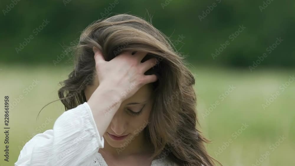 Beautiful woman combs her hair with hand enjoys herself outdoors slow motion Beautiful woman combs her hair with hand enjoys herself outdoors slow motion