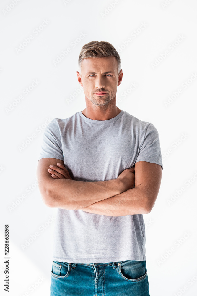 handsome adult man in blank grey t-shirt looking at camera with crossed arms isolated on white handsome adult man in blank grey t-shirt looking at camera with crossed arms isolated on white