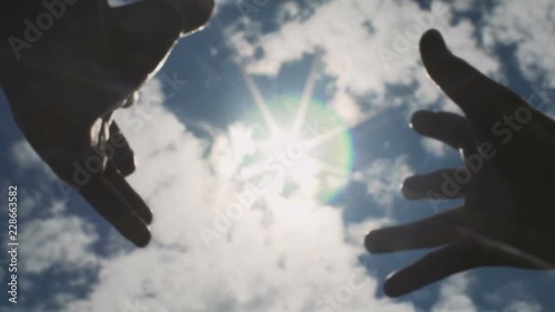 Hands reaching to sun, striving for God, looking for answer in skies above slow