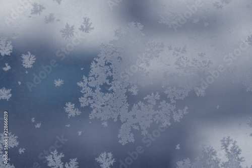 Winter ice pattern on the frozen window. Texture, background for inserting text. New Year theme. Winter. Cold.