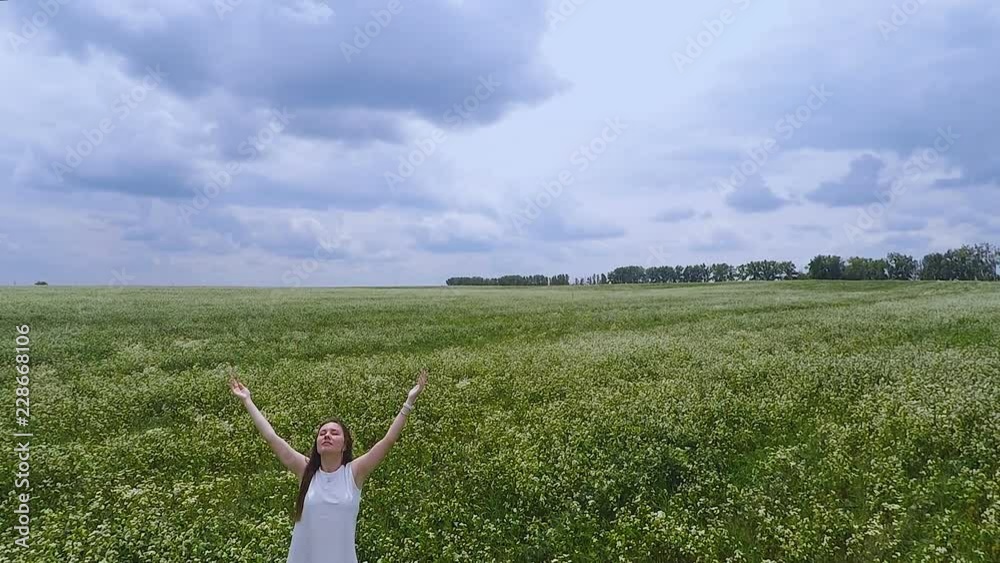 Female in fields rising hands to sky, oneness with nature prayer to God ask help Female in fields rising hands to sky, oneness with nature prayer to God ask help