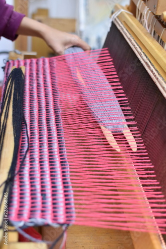Woman's hand weaving on a loom