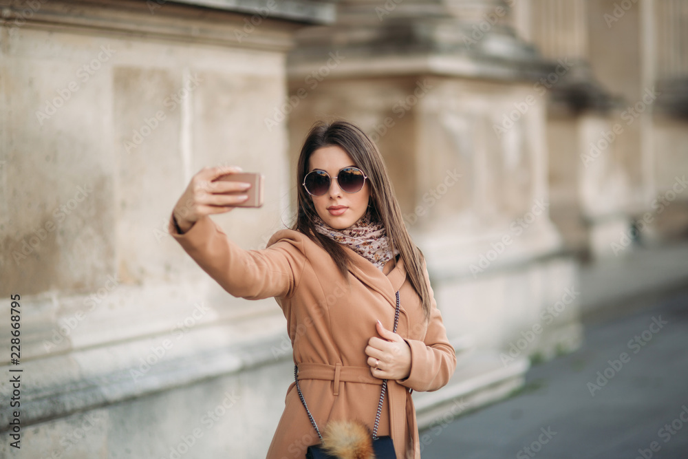 Fototapeta premium Beautiful girl in sunglasses make photo on smartphone. selfie