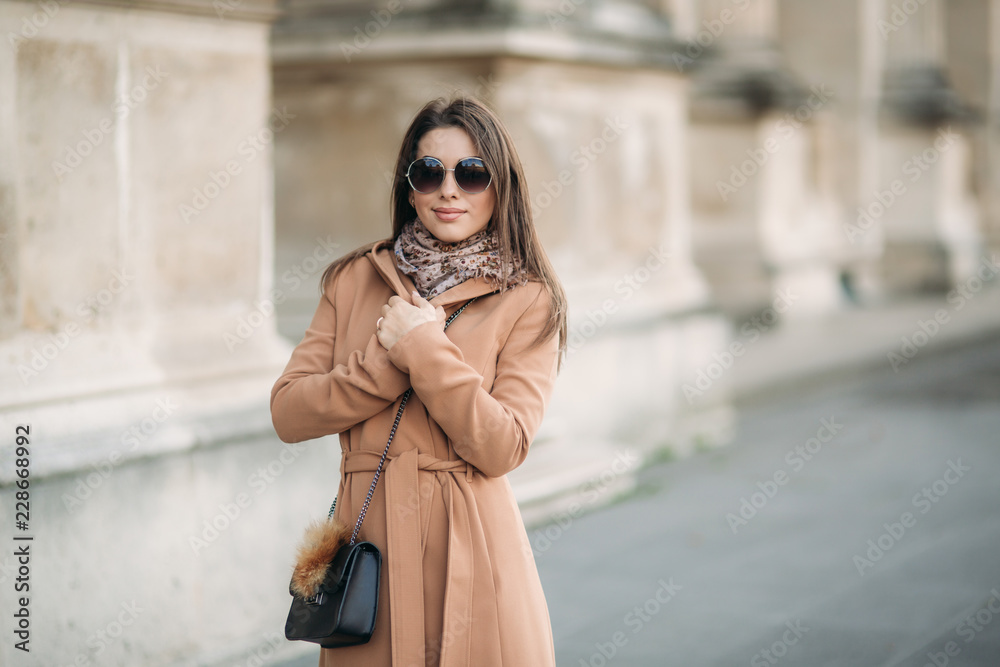 Attractive lady in autumn coat and sunglasses smile to camera