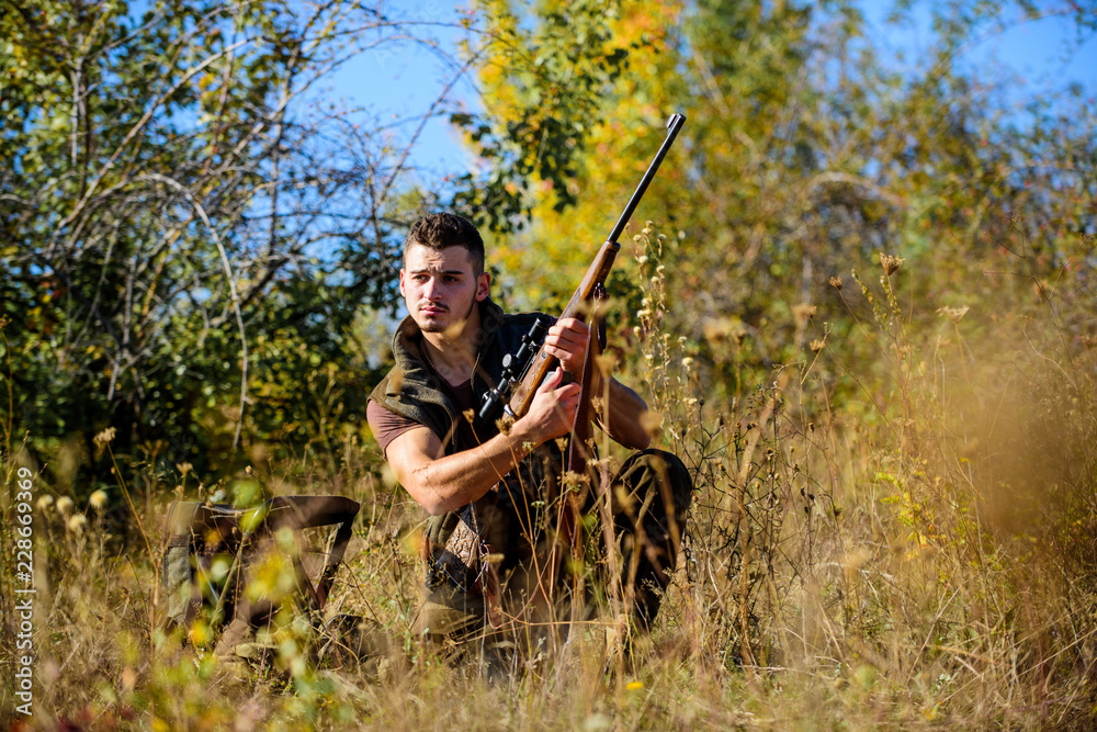 Man hunting wait for animal. Hunter with rifle ready to hunting nature background. Hunting skills and strategy. Hunting strategy or method for locating targeting and killing targeted animal Man hunting wait for animal. Hunter with rifle ready to hunting nature background. Hunting skills and strategy. Hunting strategy or method for locating targeting and killing targeted animal