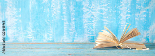 open book on blue paint background, panorama, reading, education, literature, good copy space