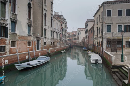 Obraz Wąska kolorowa ulica z łodzią w Wenecja, Włochy. Sceniczny piękny widok Wenecja kanał z odbiciem w wodzie. Stare budynki i gród Wenecji. Romantyczna wycieczka w Wenecji.
