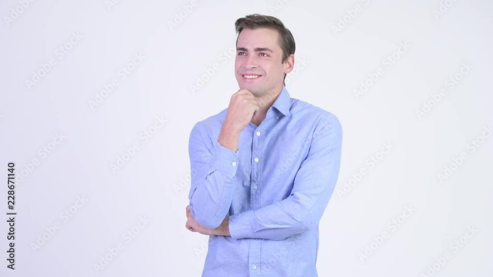 Young happy handsome businessman smiling while thinking Young happy handsome businessman smiling while thinking