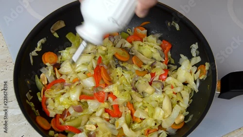 Adding cooking oil to fried vegetables in a wok during a cooking process