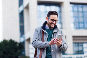 Successful young handsome businessman using phone