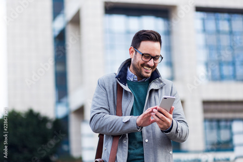 Successful young handsome businessman using phone