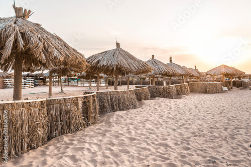 beach umbrellas from natural materials by the sea on the sand