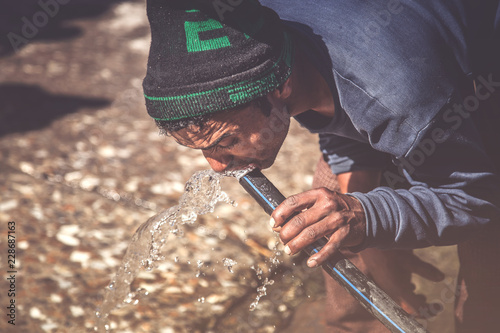 Canvas Print Poor Indian man Drinking Water