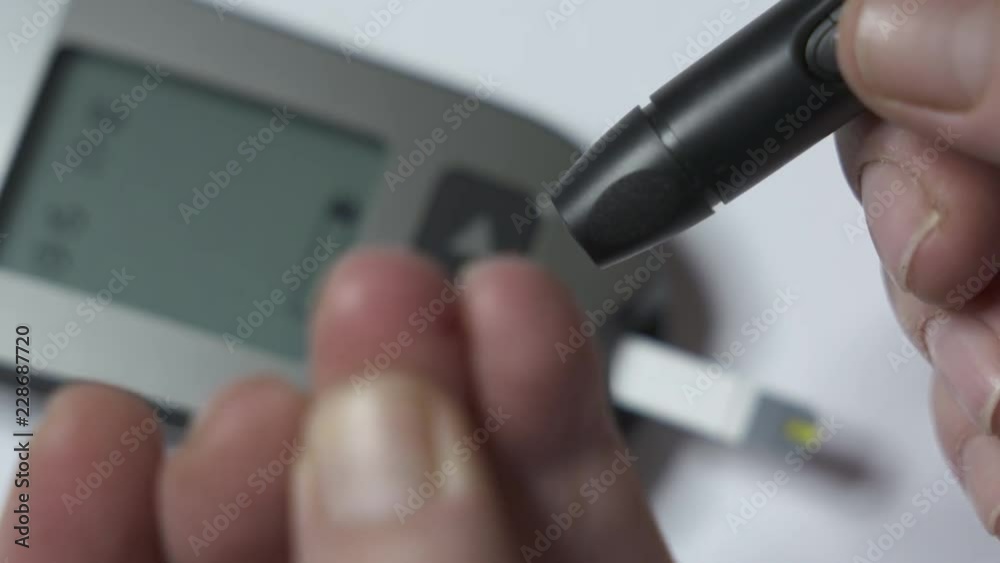 Patient with diabetes using a blood glucose meter to test blood glucose