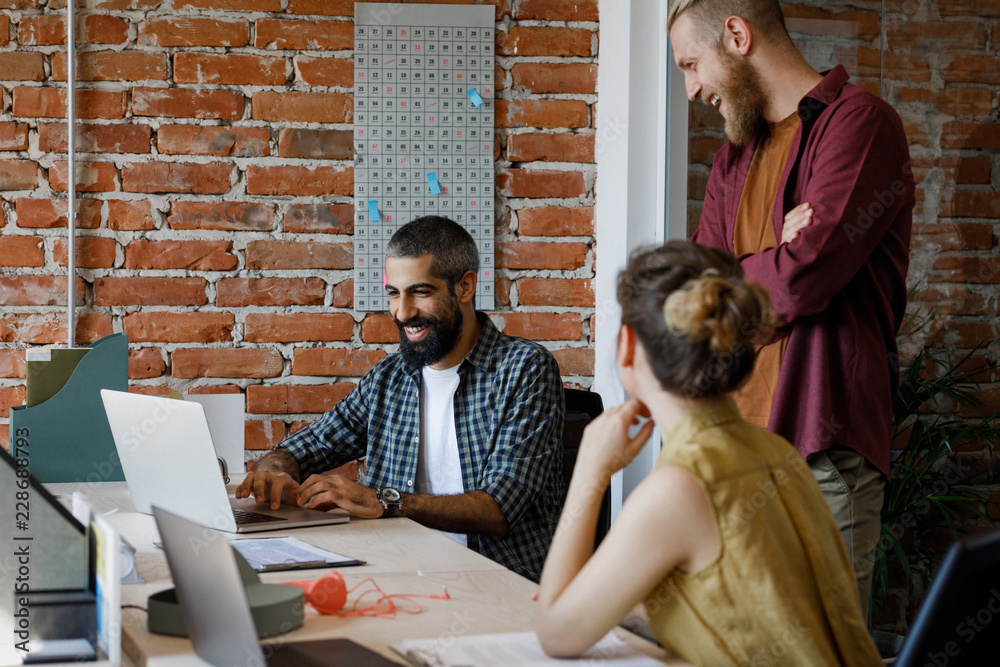 © LUMINA IMAGES - Group of young casual Caucasian businesspeople working together at modern office space.