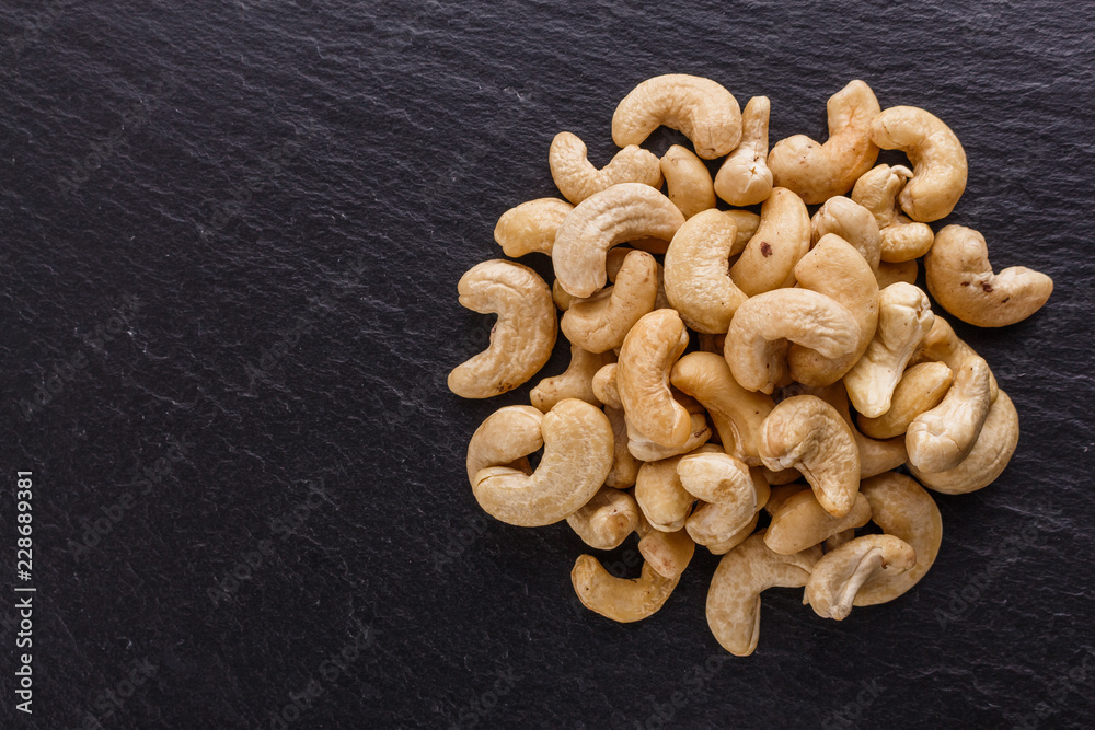 Fototapeta premium cashew nuts on a dark stone background