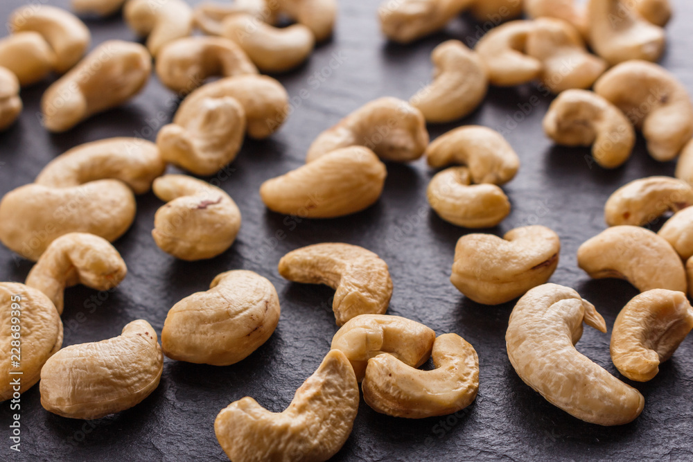 cashew nuts on a dark stone background
