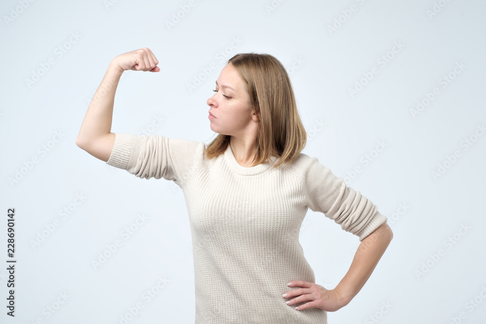 Portrait of a strong young girl showing bicep being self confident and strong. Portrait of a strong young girl showing bicep being self confident and strong.