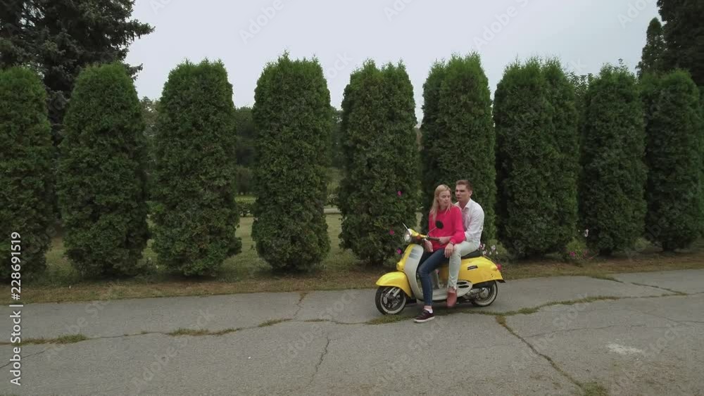 Young couple hugging on scooter outdoors. Shot on drone Young couple hugging on scooter outdoors. Shot on drone