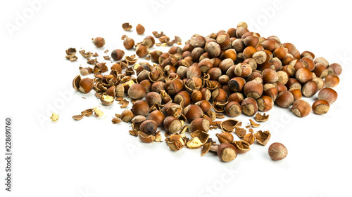 Heap of hazelnuts scattered on white background