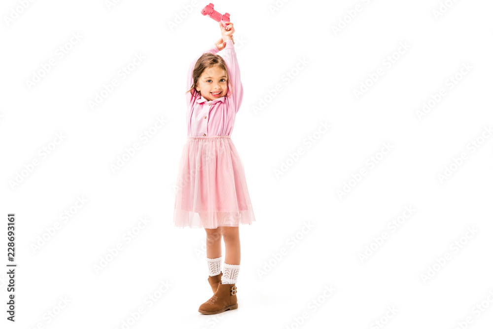 cute kid in pink dress holding gamepad isolated on white