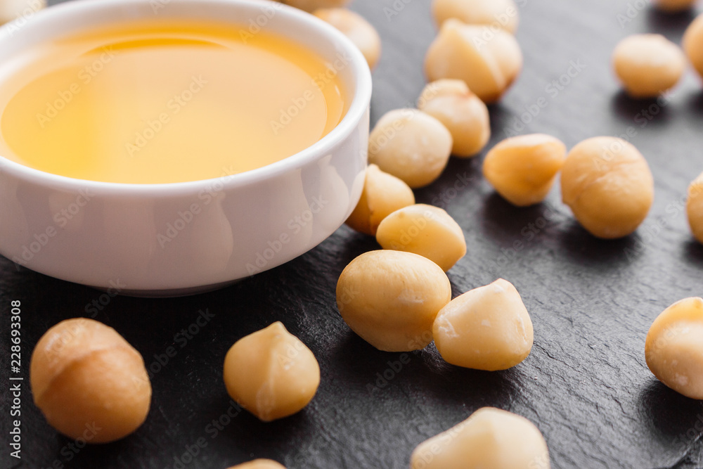 delicious macadamia nuts on a dark stone background delicious macadamia nuts on a dark stone background