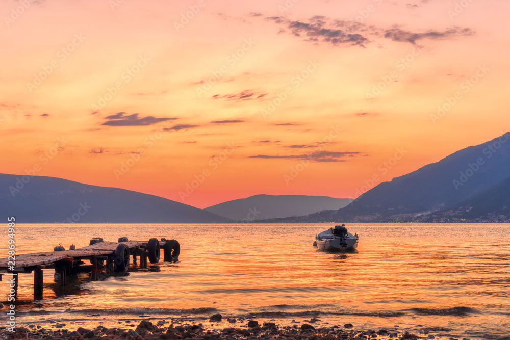 Naklejka premium Beautiful sunset with pier and fishing boat