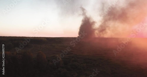 clouds of smoke come from an object burning in the field